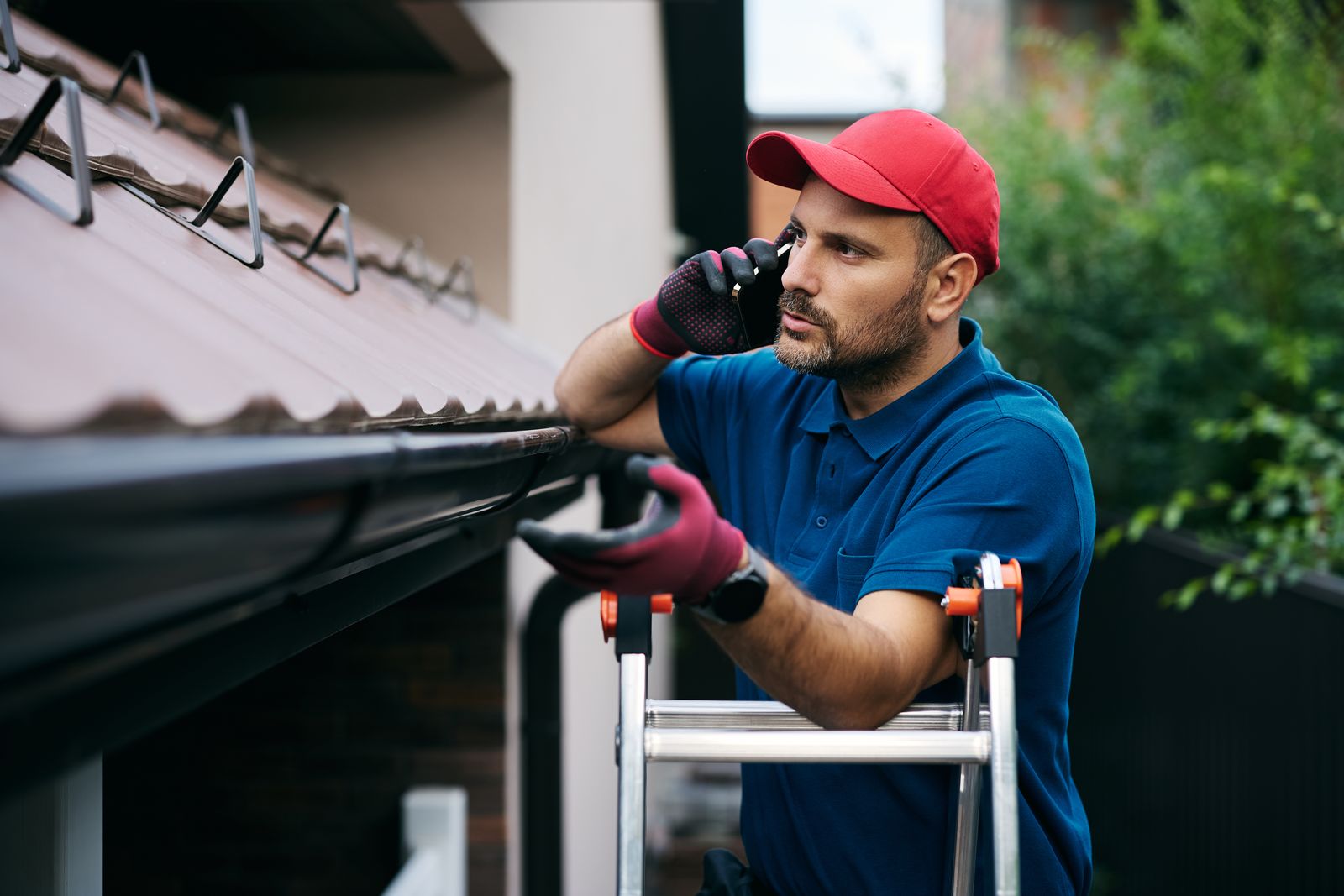 Gutter technician on a call beside an extension ladder
